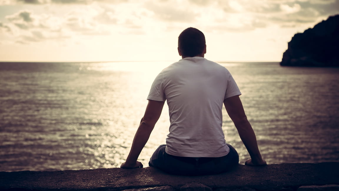 Back of man staring off into ocean horizon