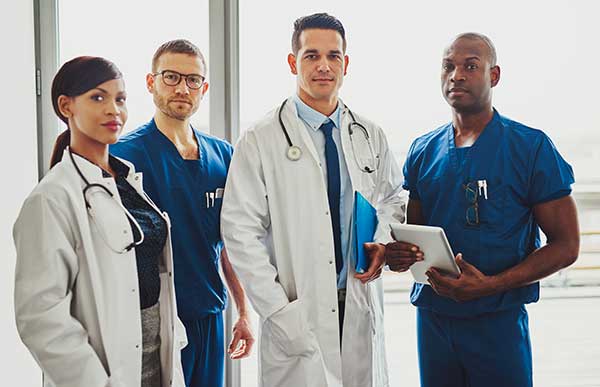 one female doctor, one male doctor, and two male medical workers posing for camera