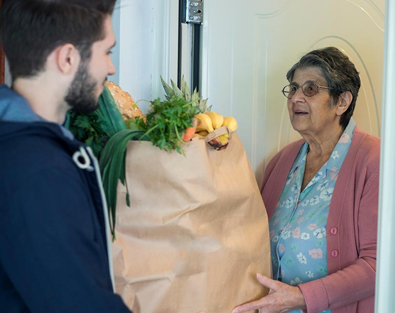 elderly women receiving a delivery of groceries