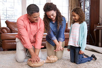 family practicing CPR in their home