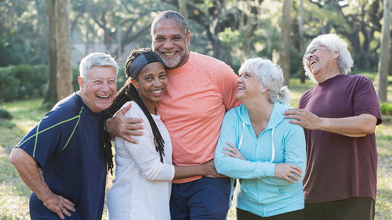 senior group of friends hugging outdoors