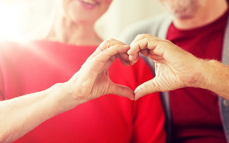 senior couple making heart hands senior couple making heart hands