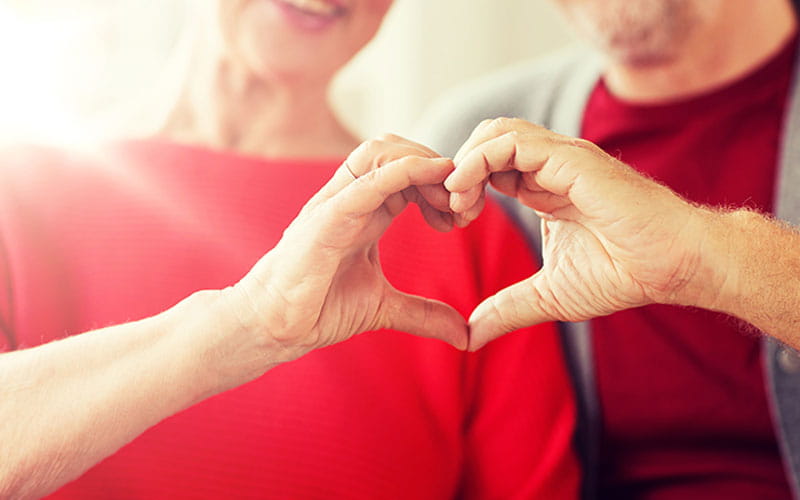 senior couple making heart hands