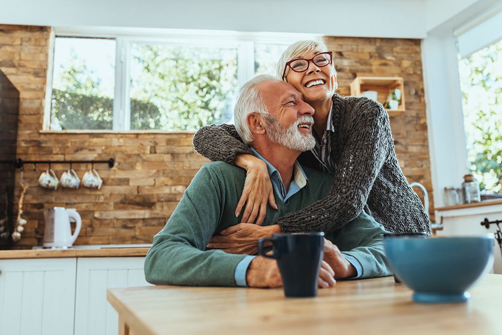 senior couple hugging in kitchen